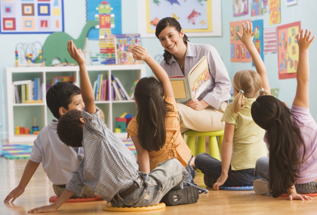 Teacher reading book to children